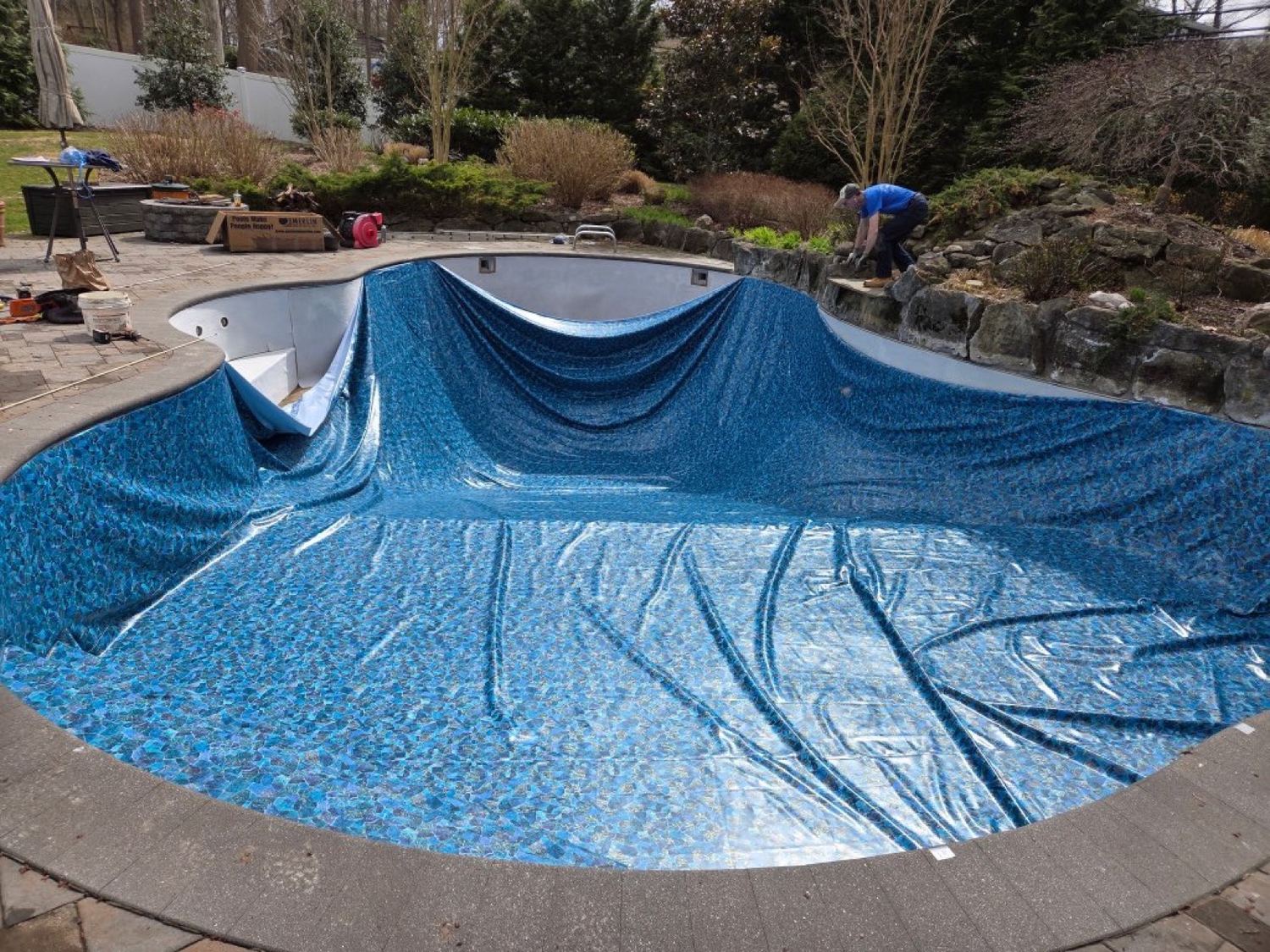 A crew member fitting a replacement pool liner